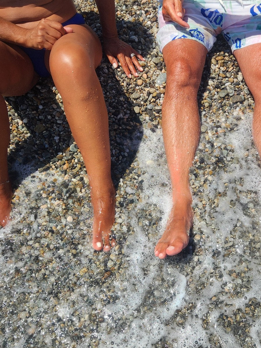 Feet in the surf on a pebble beach